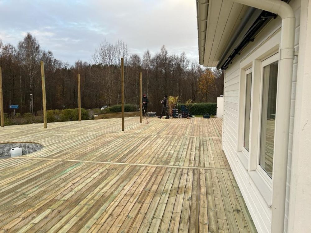 Trädäck med trappsteg mot trädgård
