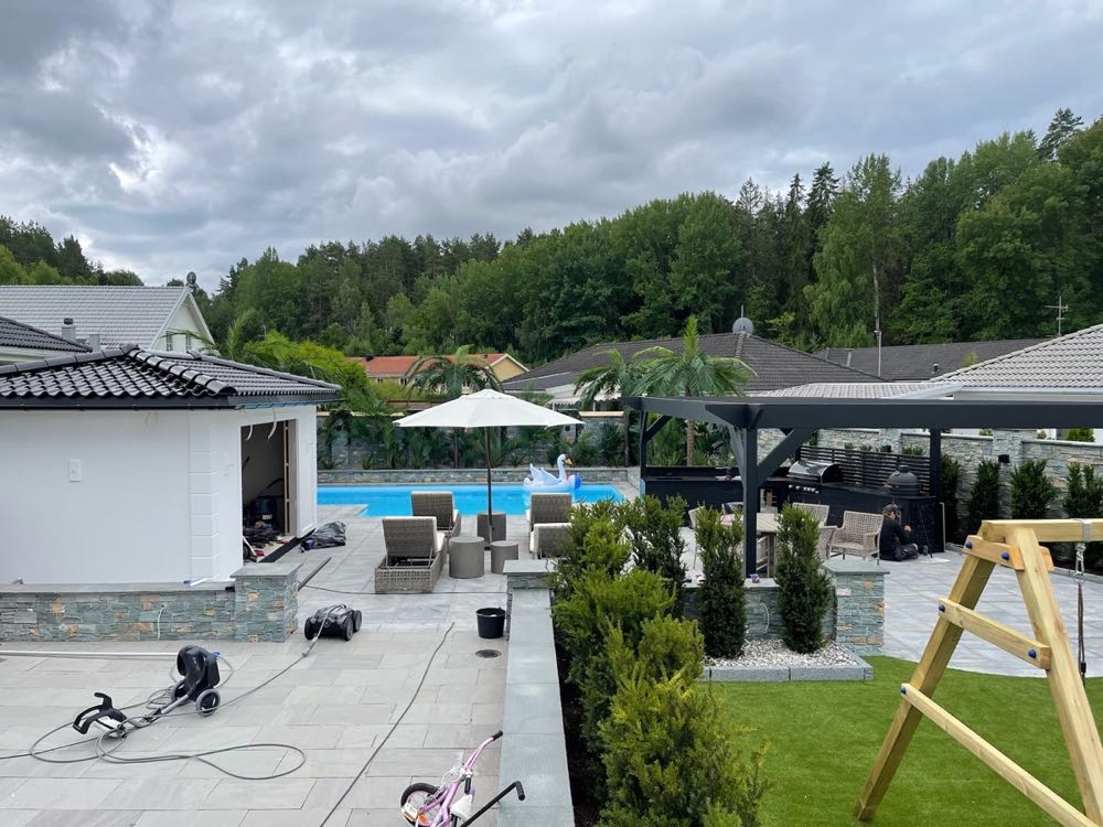 Poolmiljö med planteringar och sittplatser